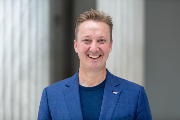 A person in a blue suit smiling 