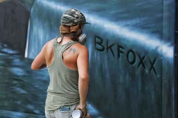 A person spraypainting on a wall