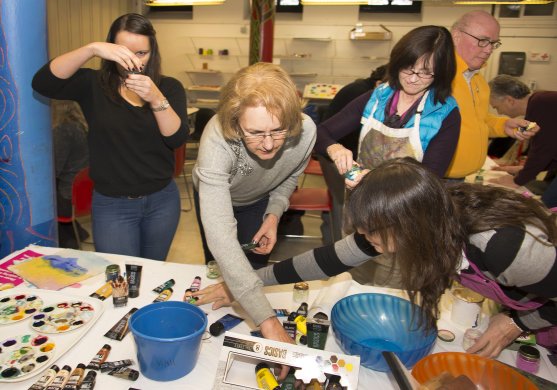 Adults work on projects during a studio art workshop