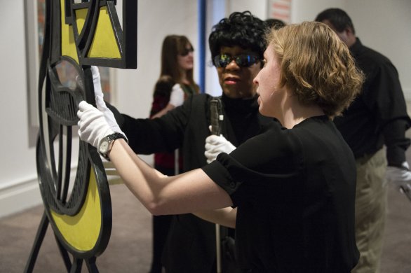 Accessibility and Community Programs Coordinator Teri Fallesen guides a blind woman during a Verbal Description Sensory Tour.