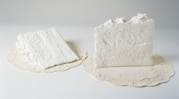 Two sculptures that look like all-white pieces of cake