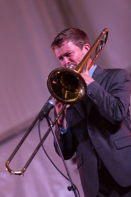 A man in a suit playing a trombone