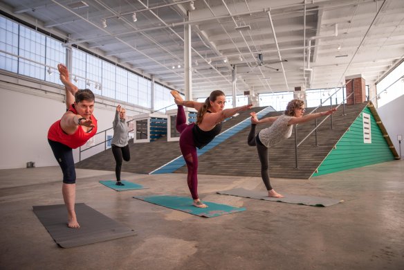 Four women doing yoga in a large room
