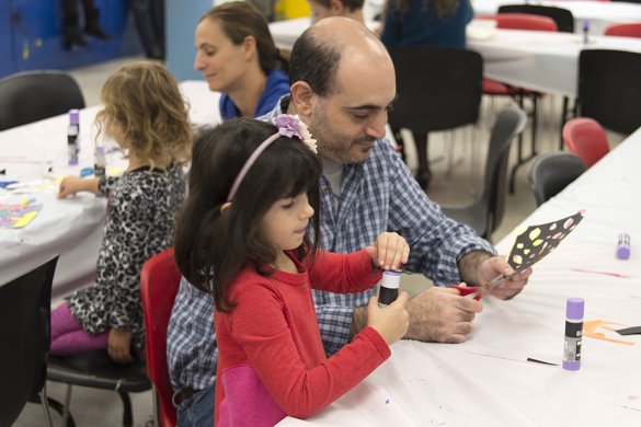 A father and daughter making a collage in the classroom