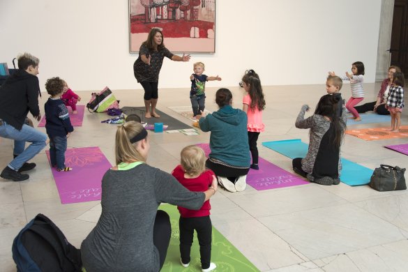 Kids and caregivers doing yoga in the Sculpture Court