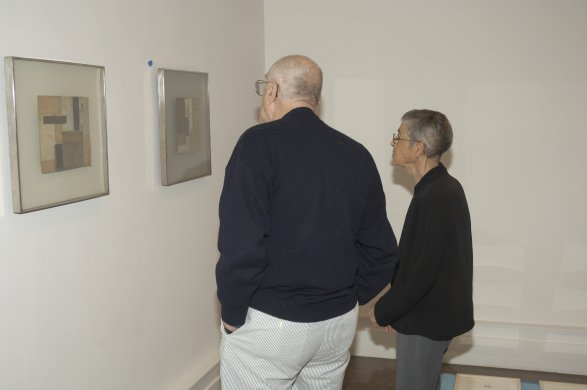 Natalie and Irving Forman contemplate works by Robert Nickle during the installation of Works on Paper: The Natalie and Irving Forman Collection