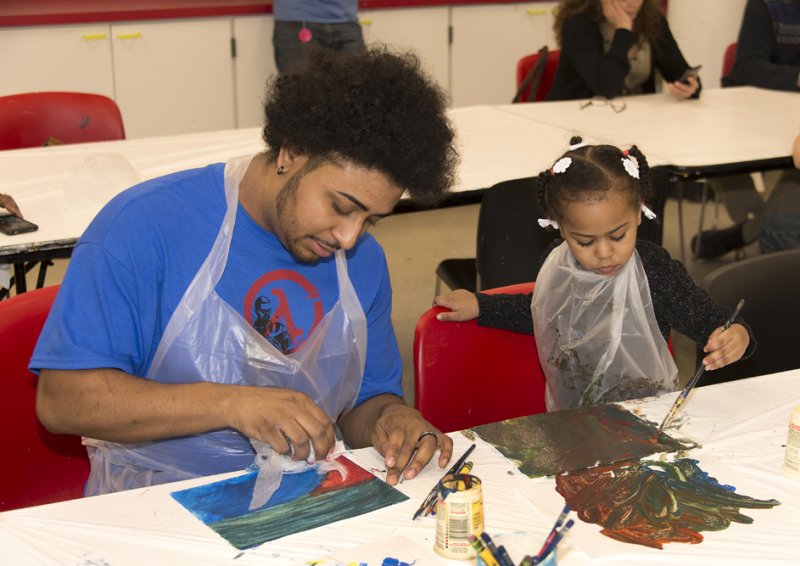 A father and daughter making art in the classroom