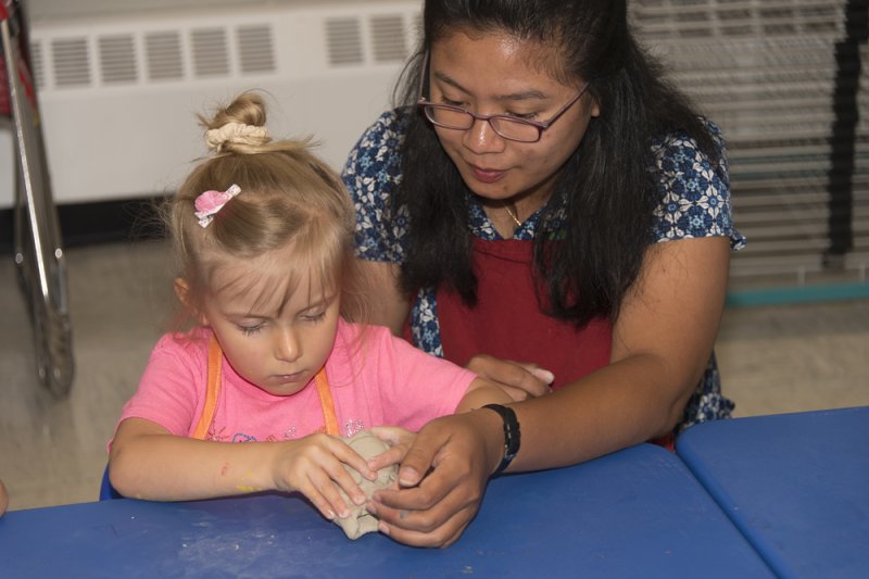 Photo of child and teacher making artwork