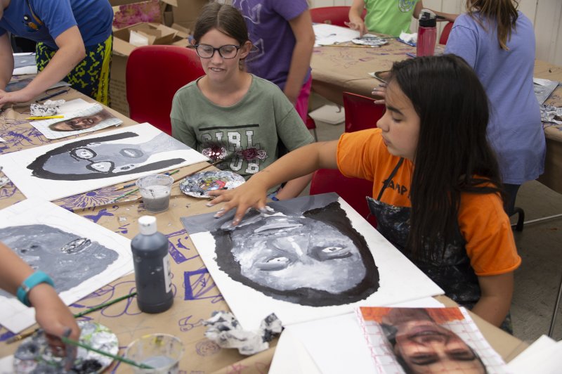 Two girls painting at a table