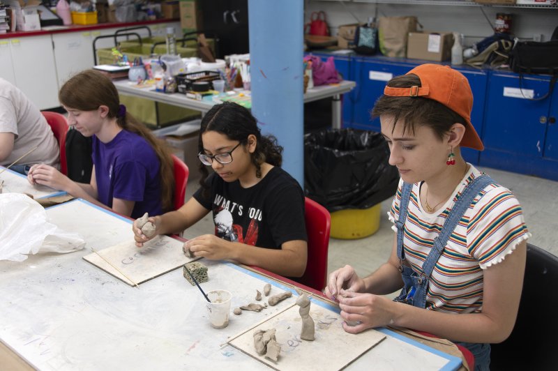 Three teenagers making art