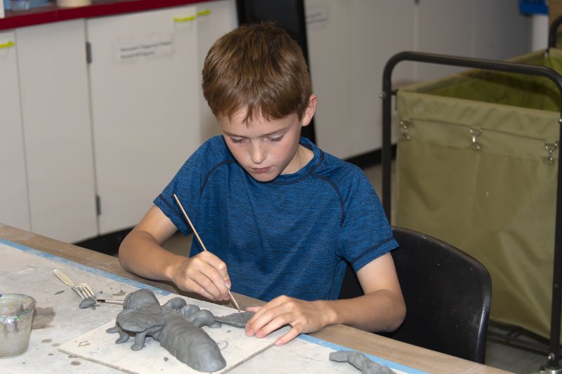 A boy making a clay sculpture