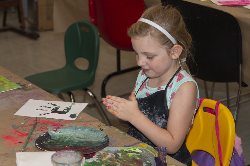 A girl making prints of her hand with paint all over it