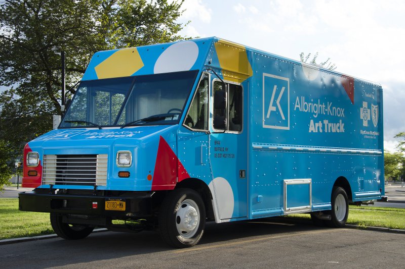 Big blue truck with yellow, red, and white shapes on it