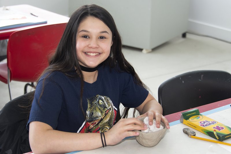 A teenage girl making a clay pot