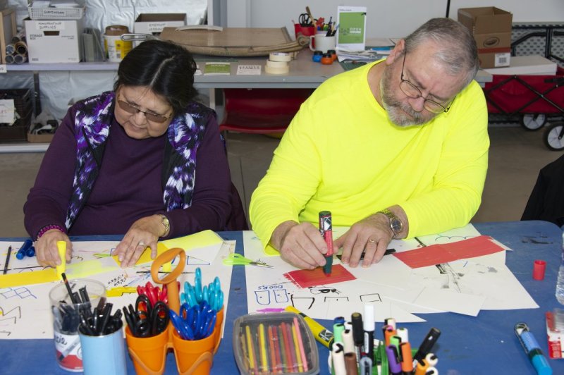 A woman and a man making art at a table