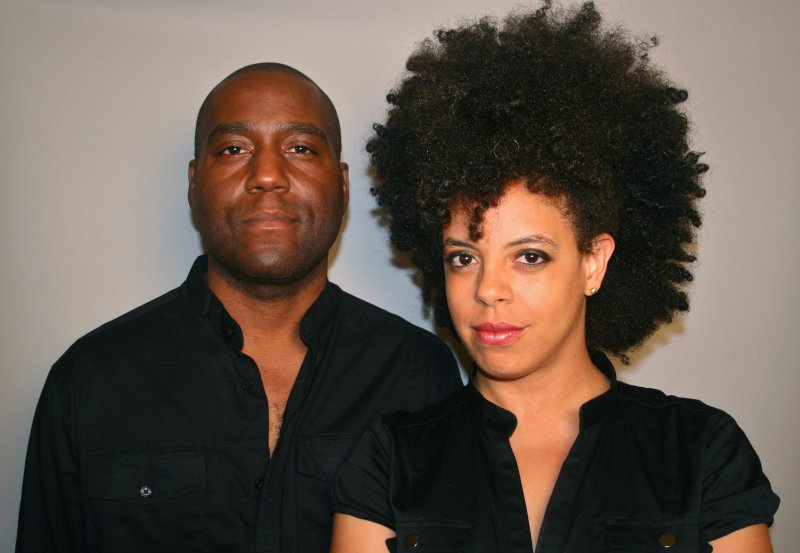 A Black man with a bald head and a Black woman with a curly afro