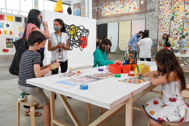 Kids making art at a big table in a large building
