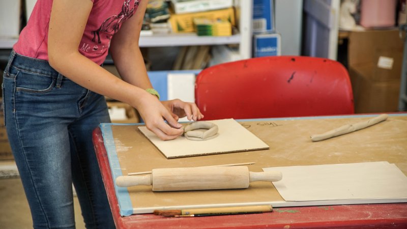 A girl making a clay pot