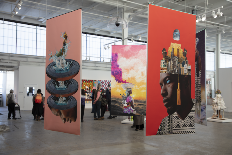 Hanging screenprints of Afrofuturist collages in a large warehouse exhibition space