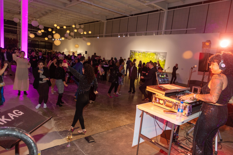 group of people dancing in front of a DJ 