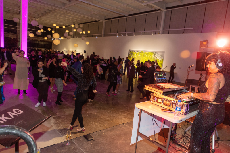 A DJ performs for a group of people dancing 