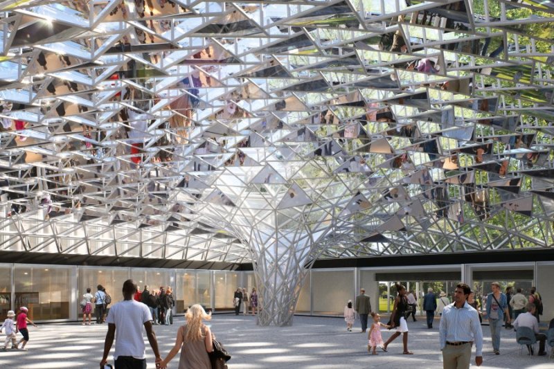 Glass mosaic ceiling/canopy that funnels down to the floor in an open space with people walking around 
