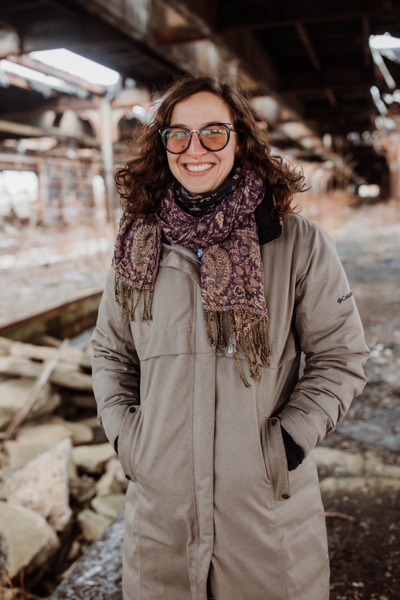 Photo of a woman wearing glasses, a scarf, and a winter coat