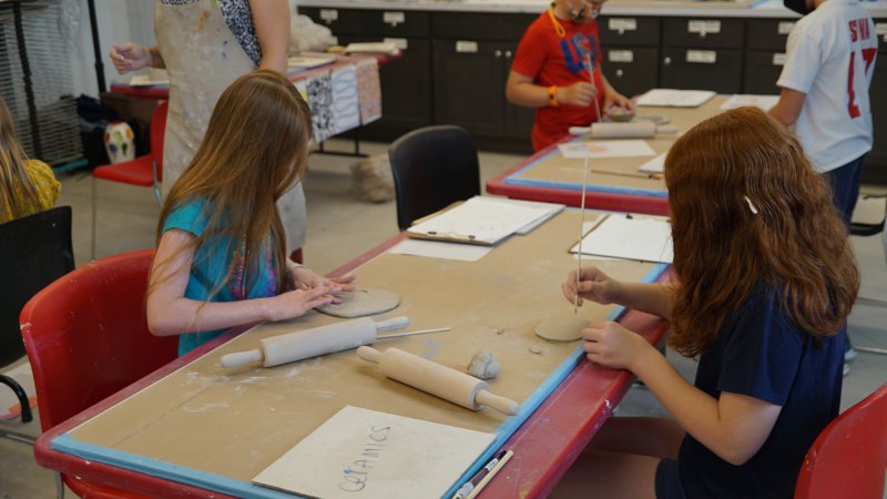 Two young girls working with clay