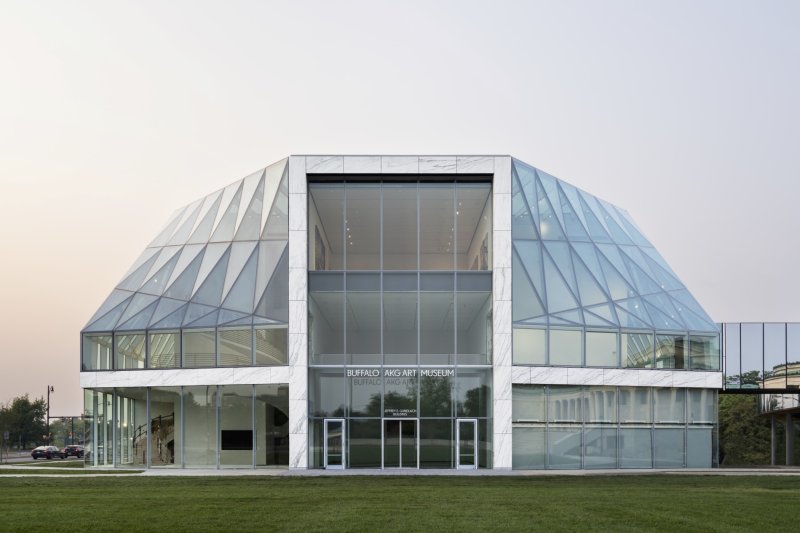 A large glass museum building at sunset