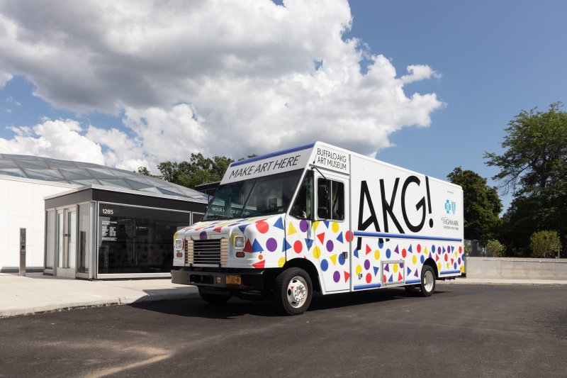 White truck with red blue and yellow shapes and black letters that says AKG!