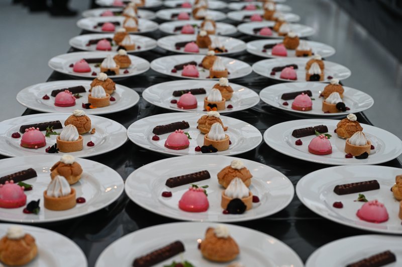 A table filled with white plates carrying small dessert pastries
