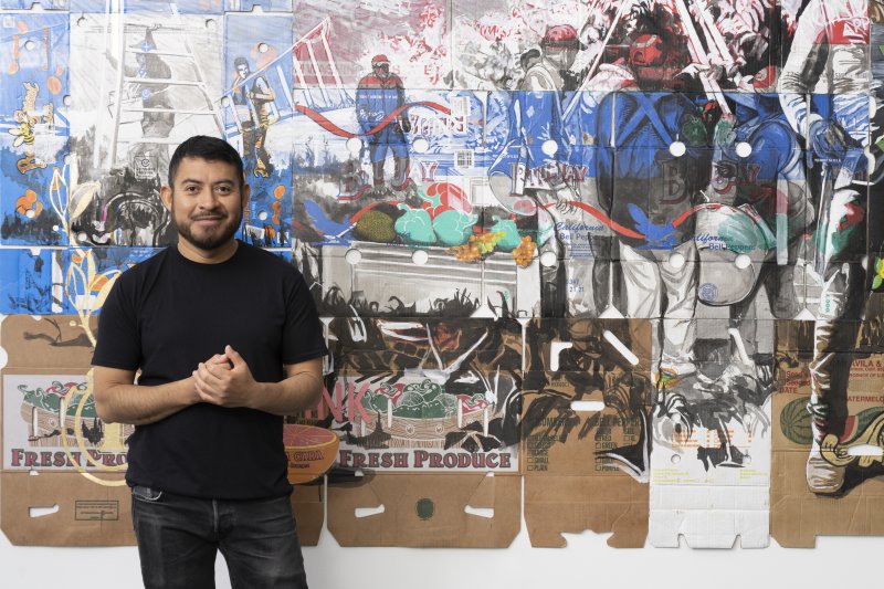 A man standing in front of a large artwork on the wall