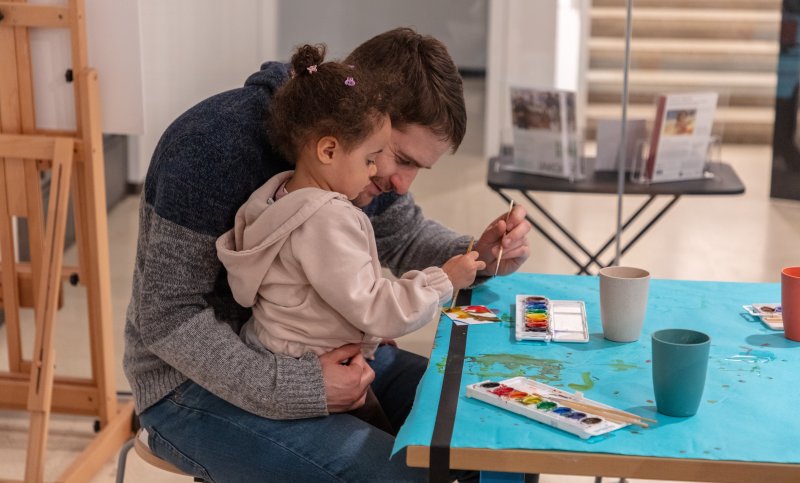 A parent and child working on an art project together