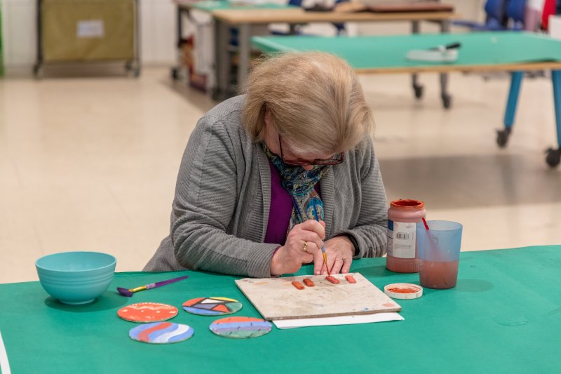 A woman painting clay pieces