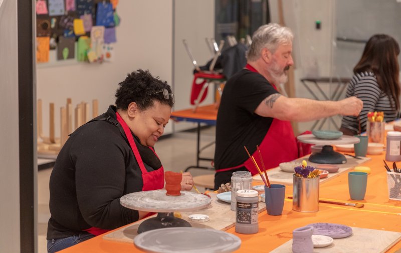 Adults working in a clay class