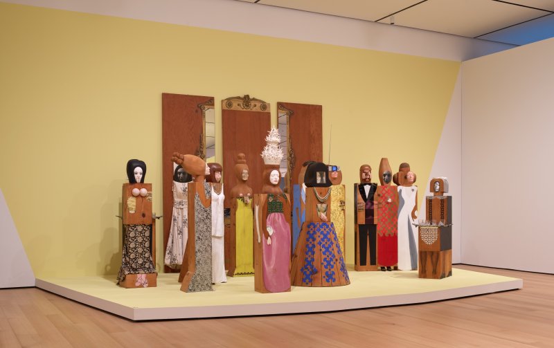 A grouping of wooden sculptures that resemble a party