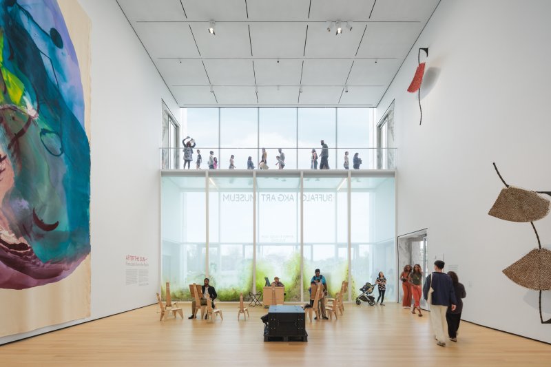 A tall gallery space with visitors walking around