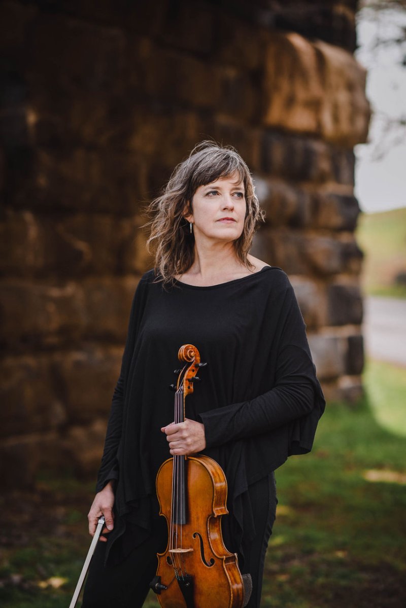 A woman posing with a violin