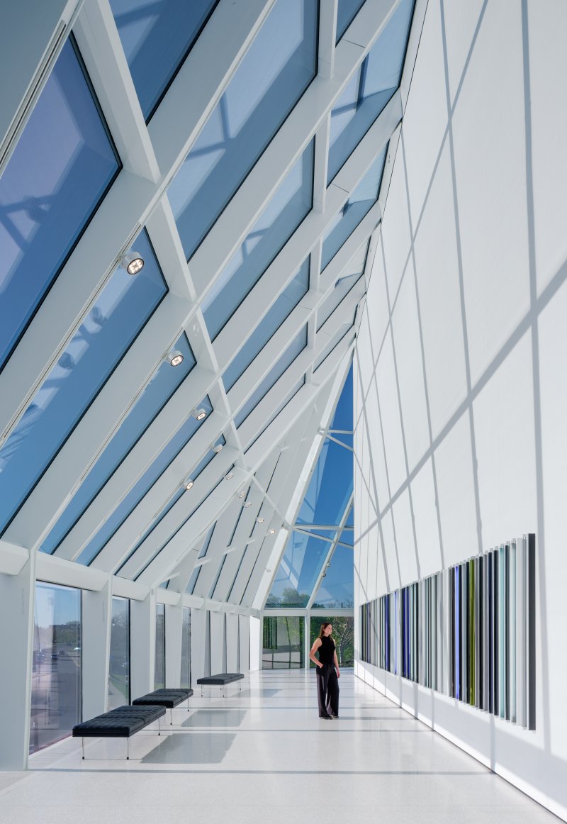 A white corridor with large glass windows and ceiling 