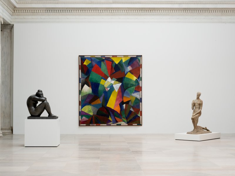 A gallery space with two sculptures and a large abstract painting 