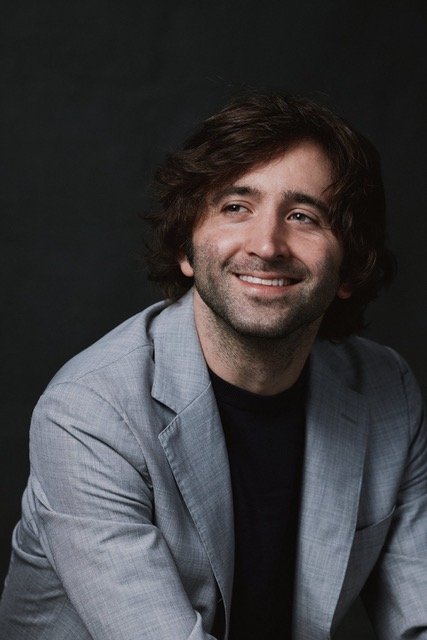 Headshot of a man smiling and looking away from the camera