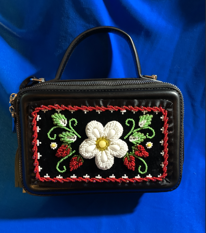 A black beaded purse on a blue background