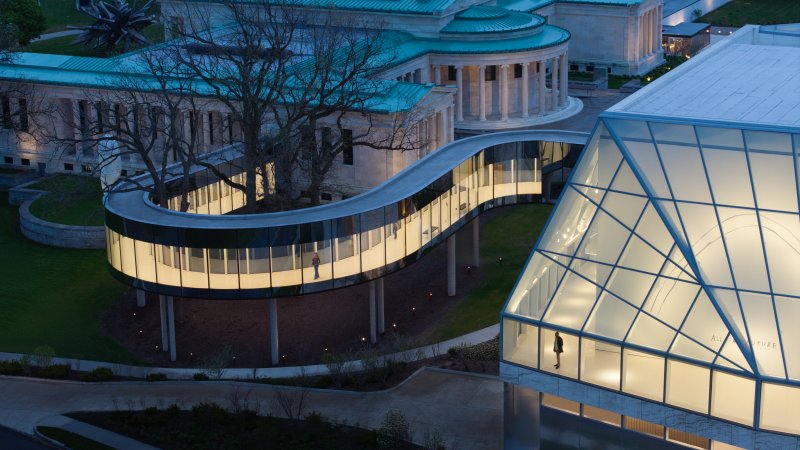 Aerial view of a bridge connecting a traditional marble museum building to a modern one