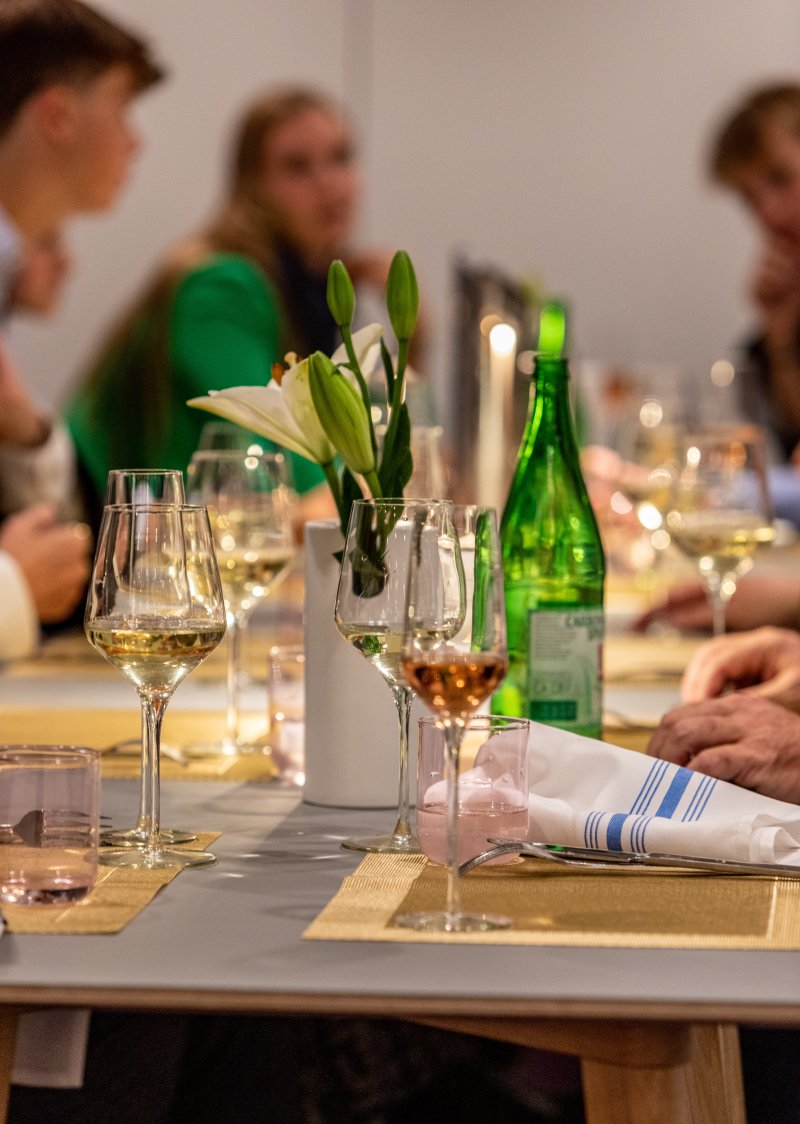 People at a restaurant with glasses of wine at their table