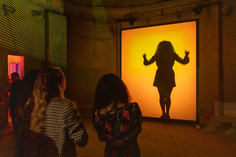 A silhouette shown through a vibrant orange screen