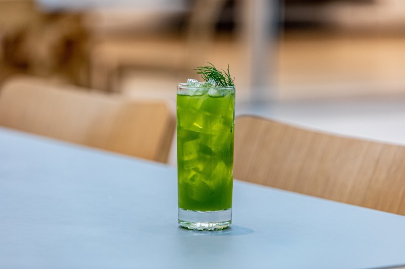 A green cocktail in a clear glass