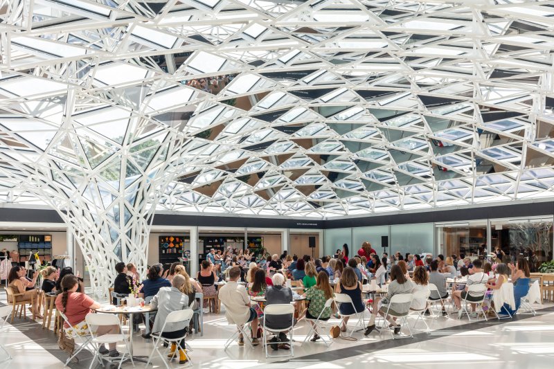 People gathered under a glass mosaic ceiling