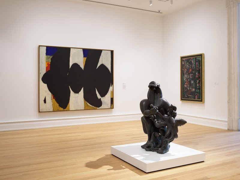Installation view of a sculpture and two paintings on white gallery walls