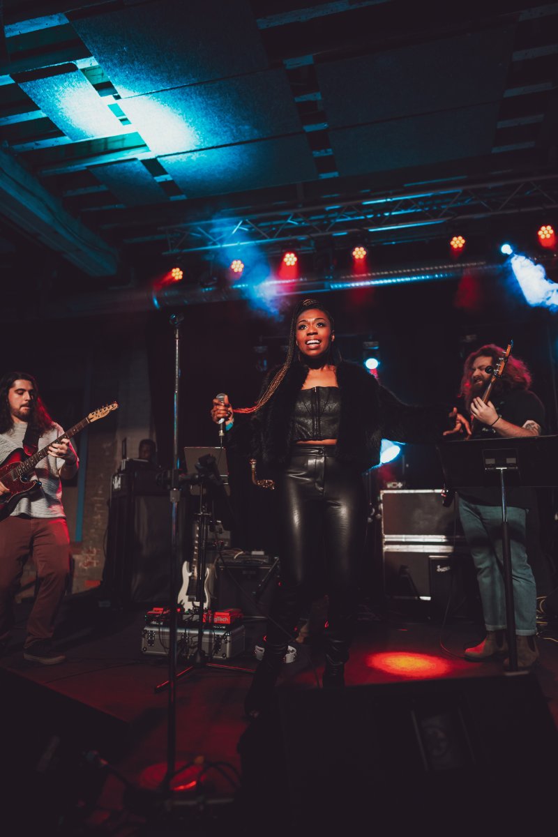 A band performing under neon lights on a stage