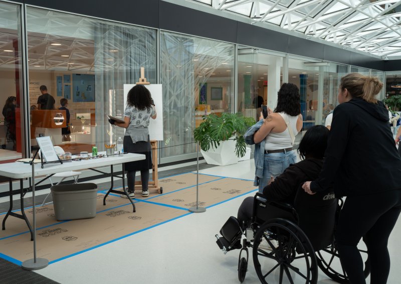 People watching an artist do a live painting demonstration